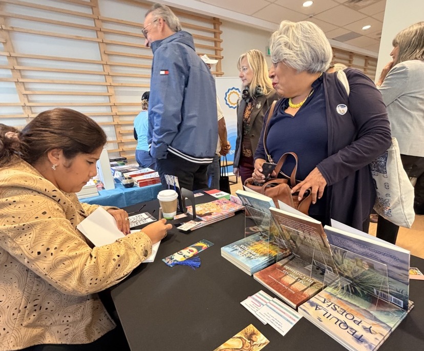Viridiana signing a book with a reader in Ottawa